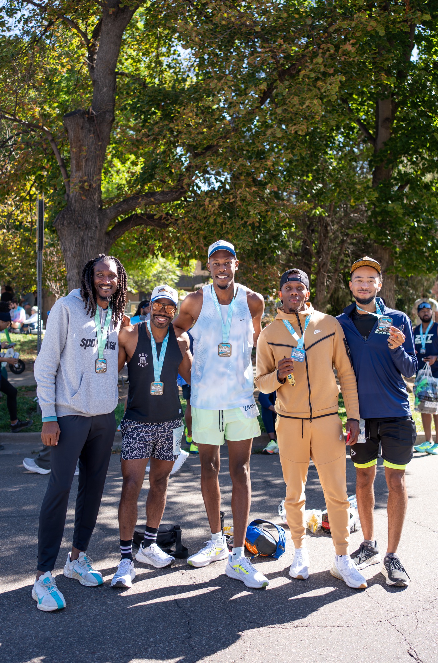 Houston run club photography — ZFT runners celebrating with medals after race
